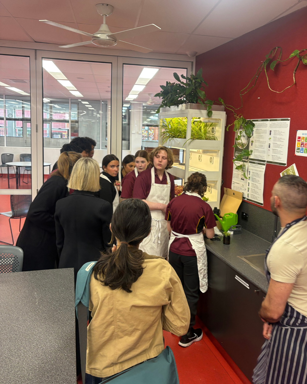 Students in aprons gathered around a Farmwall for a workshop