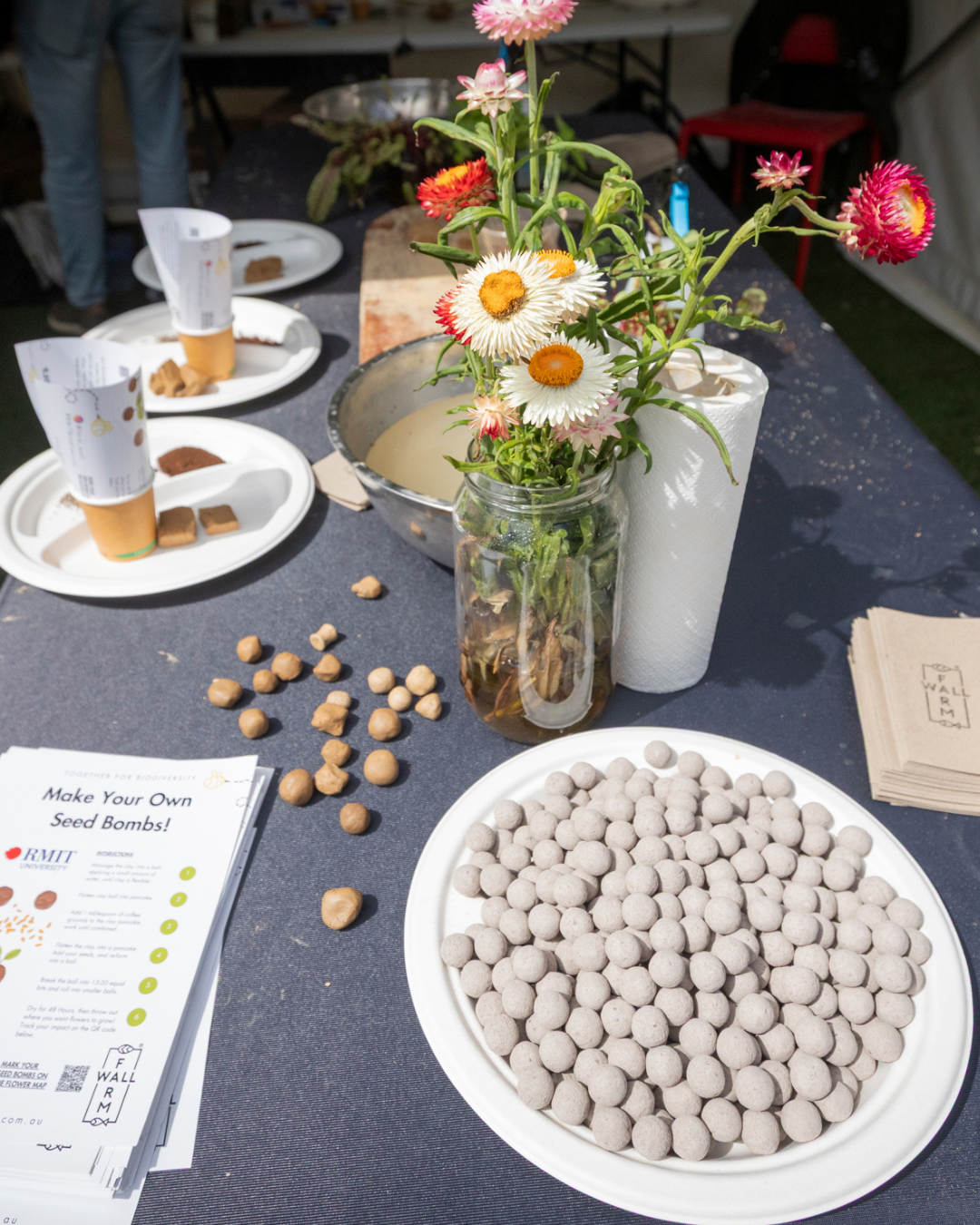 Seed bomb materials and fresh flowers on a workshop table